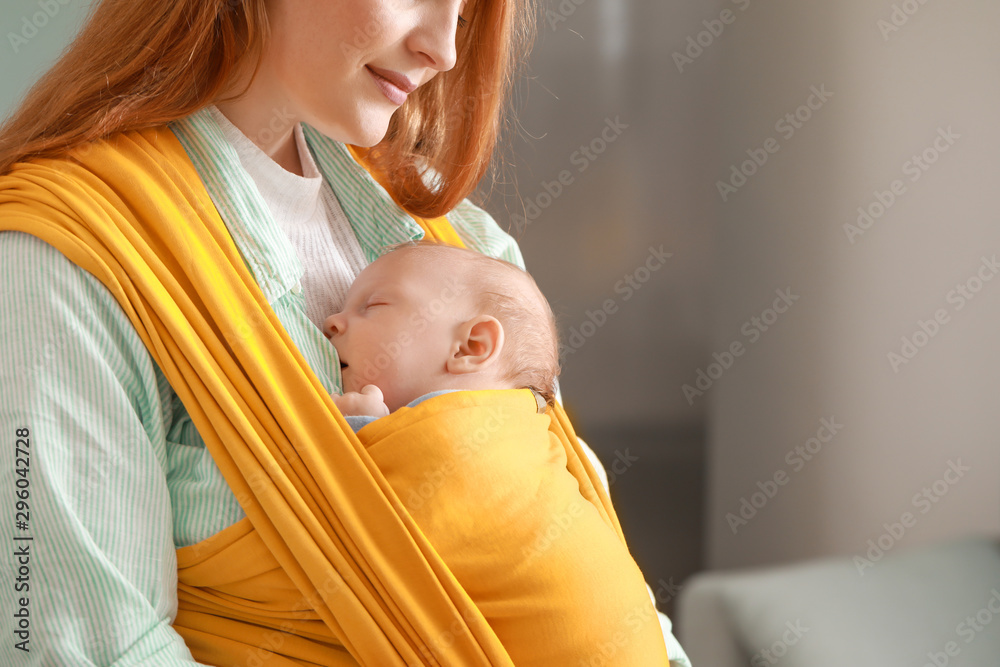 Young mother with little baby in sling at home - obrazy, fototapety, plakaty 