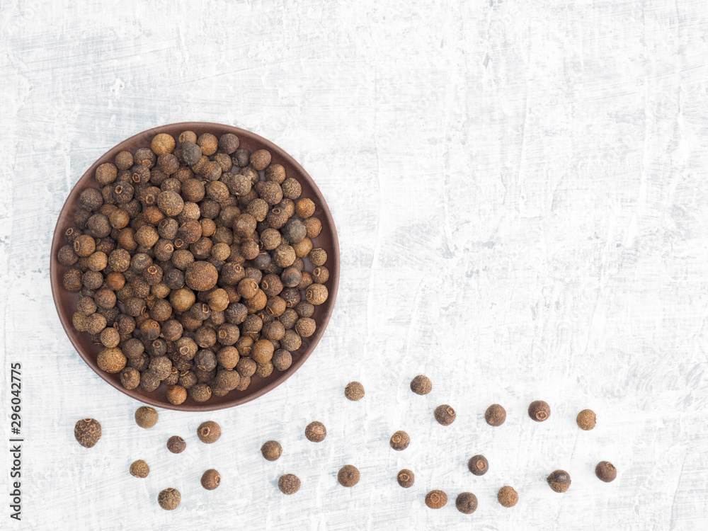 Spices and herbs help maintain good health and improve appetite, top view on white concrete background. Allspice. Modern apothecary, naturopathy and ayurveda concept. Spices and herbs help maintain good health and improve appetite, top view on white concrete background. Allspice. Modern apothecary, naturopathy and ayurveda concept.