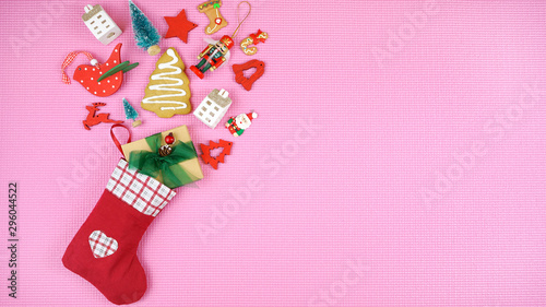Photography Festive Christmas concept with children's stockings filled with cookies and gifts on pop color pink background with copy space