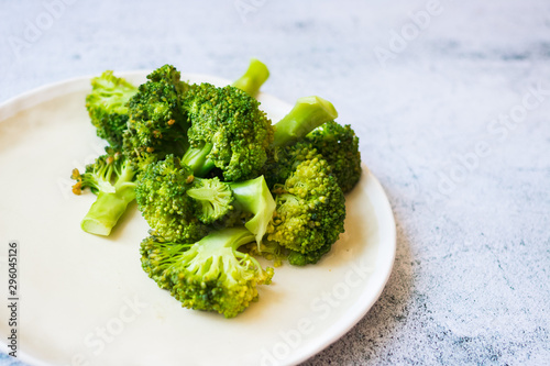 Cooked or steamed broccoli inflorescence, sprouts on plate.