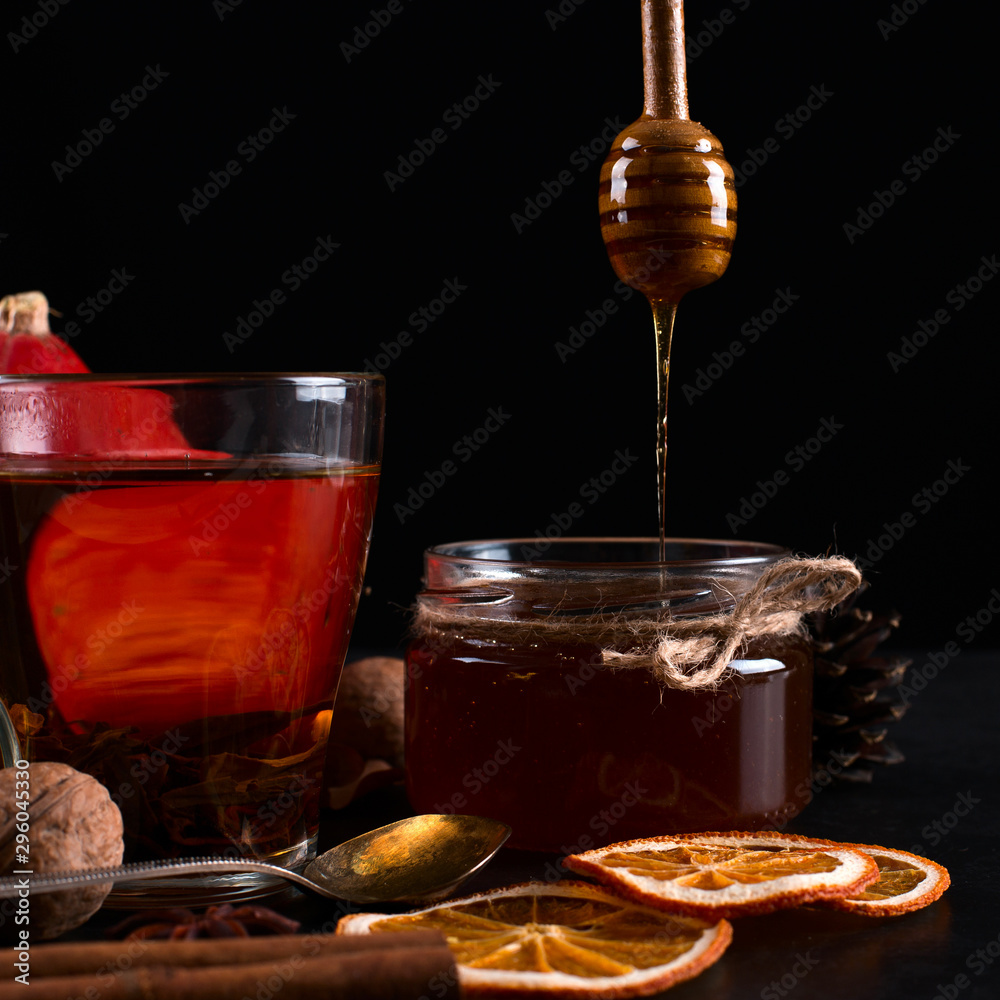 Tea, honey, fruits, cinnamon, dried oranges and nuts on a black background. autumn harvest, copy space. Tea, honey, fruits, cinnamon, dried oranges and nuts on a black background. autumn harvest, copy space.