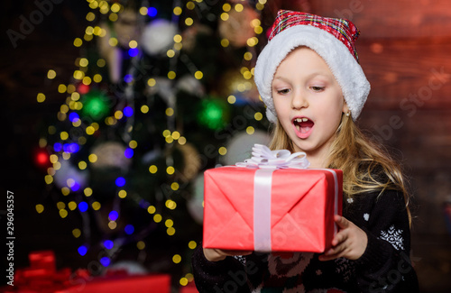 Best surprise gift ever. Adorable kid looking at gift box with surprise. Small girl keeping mouth open with big surprise on boxing day. Surprised little child holding xmas present. Surprise for her