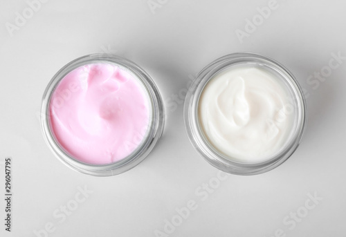 Jars of cosmetic cream on white background
