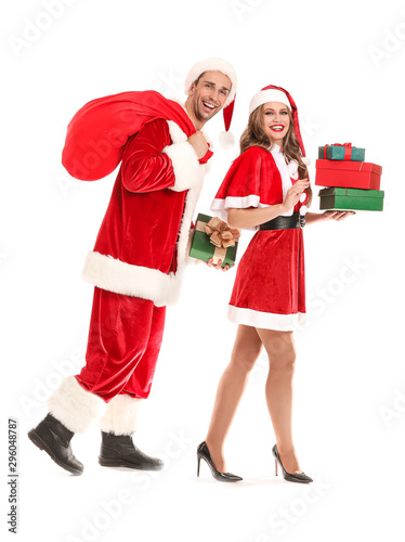 Going young couple dressed as Santa Claus with Christmas gifts on white background
