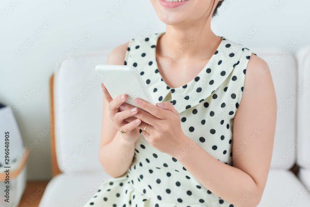 Pretty girl using her smartphone on couch at home in the living room Pretty girl using her smartphone on couch at home in the living room