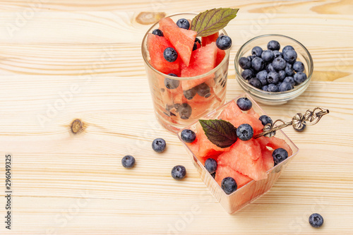 Fototapeta Naklejka Na Ścianę i Meble -  Fresh summer fruit dessert. Sweet watermelon and blueberry, purple basil leaves