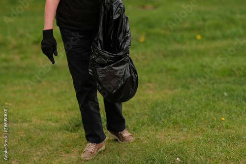 hands putting household waste into small bin bag
