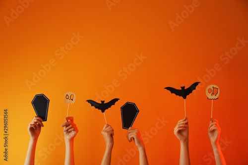 Many hands with Halloween decor on color background