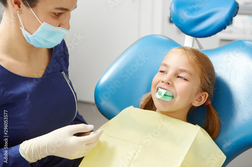 Child tries on a mouthpiece to correct the bite in the dentist's office in pediatric dentistry.