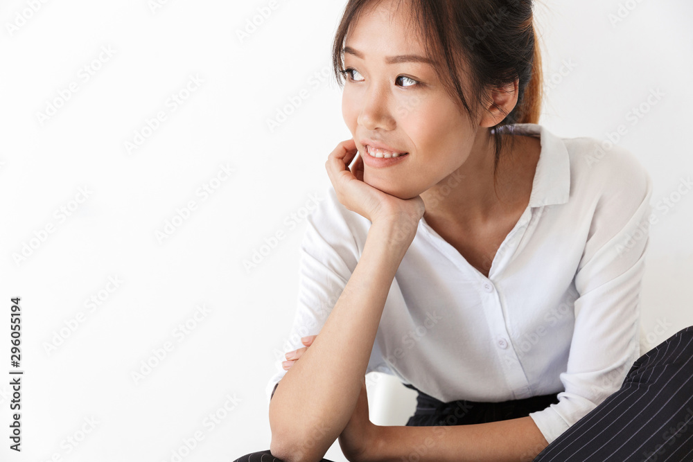 Smiling young asian woman wearing casual outfit sitting Smiling young asian woman wearing casual outfit sitting