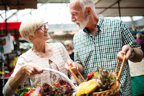 Portrait of beautiful elderly couple in market buing food