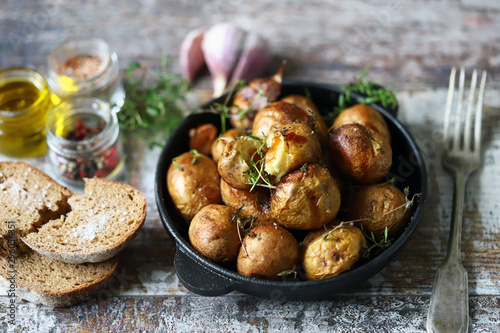 Baked potatoes in a peel in a cast-iron skillet. Rustic potatoes. Selective focus. Macro.