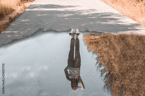 Reflection of a person standing near a puddle. Style is a reflection of your attitude and your personality. The concept of loneliness.