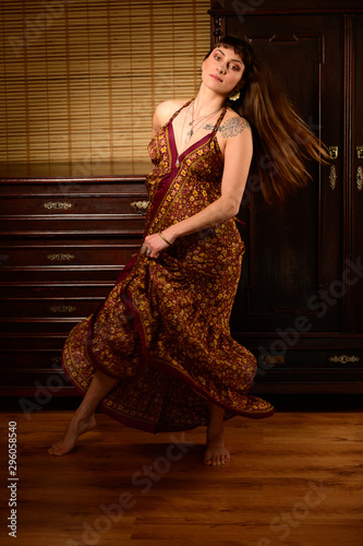 Young girl dancer and singer in gypsy dress dancing and posing on stage photo