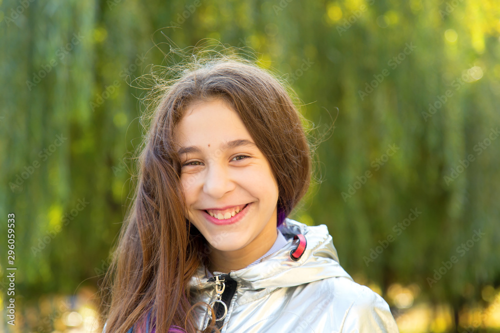 Portrait of a beautiful smiling girl on a green background of nature trees. Portrait of a beautiful smiling girl on a green background of nature trees.