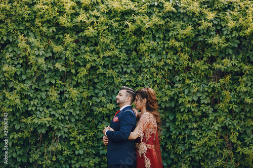 Photography Beautiful woman in a long red dress walks around the city with her husband in a