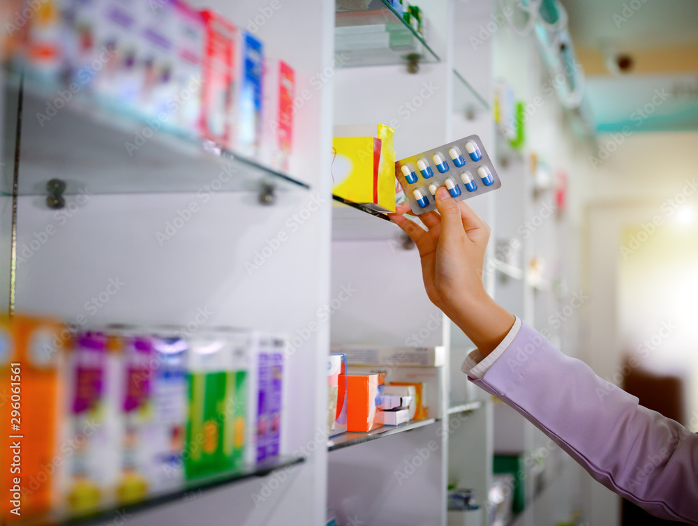 hand of woman pharmacist holding box or case of medicine container,, with customer and consultant discussion on prescribed in pharmacy drug store