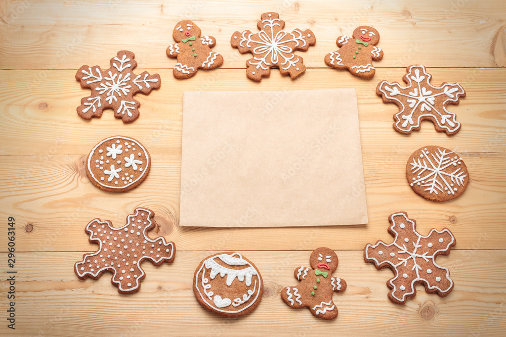 Decorated Christmas gingerbread cookies with blank paper on rustic background. Top view Decorated Christmas gingerbread cookies with blank paper on rustic background. Top view