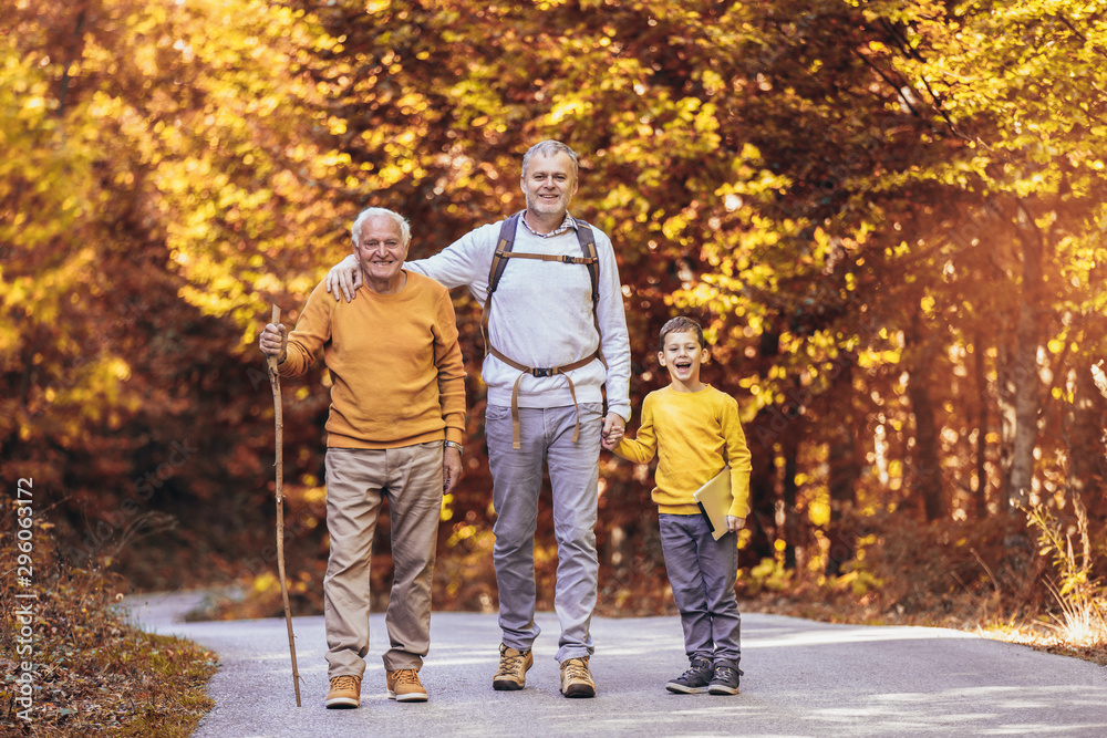 Three generation family hiking together in autumn park.