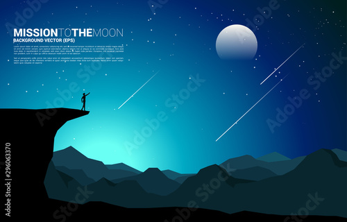 silhouette of businessman point forward from mountain cliff to the moon at night. Concept of business vision mission and goal