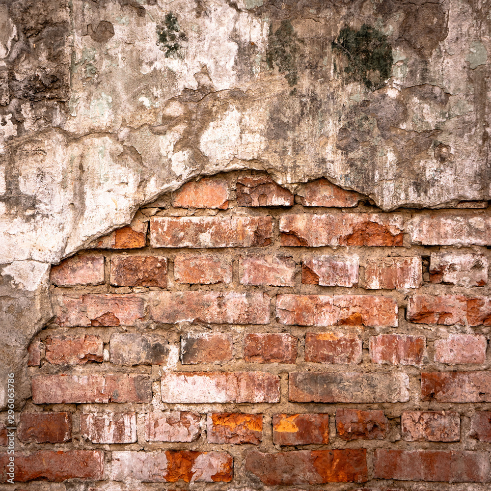 Old brick wall in a background image. Plastered Brickwall With Chipped Stucco Pieces. Red Textured Brick Wall With Damage Surface. Old Grunge Abstract Background Old brick wall in a background image. Plastered Brickwall With Chipped Stucco Pieces. Red Textured Brick Wall With Damage Surface. Old Grunge Abstract Background