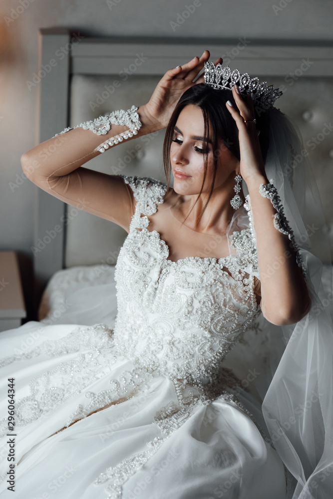 Beautiful bride with stylish make up and hair style.Beautiful happy bride corrects the crown. Beauty face. Beautiful bride with stylish make up and hair style.Beautiful happy bride corrects the crown. Beauty face.