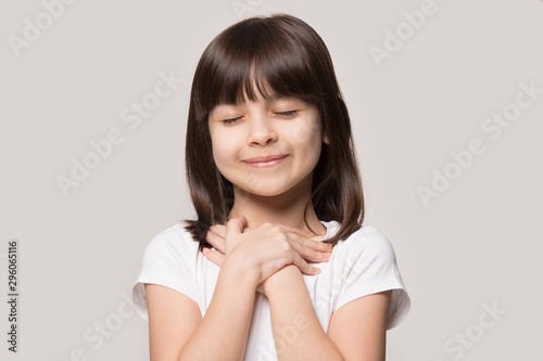 Slika na platnu Cute little girl with hands on chest praying