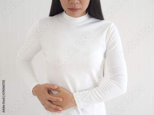 muscle pain in asian woman and she use hand touching and press her flank waist symptom of swelling cause of lift heavy use for health care concept. photo