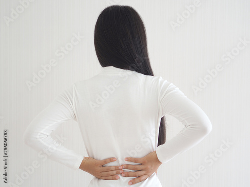 herniated disc,spondylosis and scoliosis in asian woman and she touching her back cause of strains or disc injury and spinal stenosis use for health care concept. photo