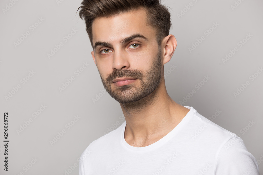 Close up of serious caucasian man posing on grey background Close up of serious caucasian man posing on grey background