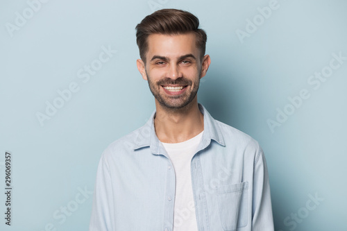 Headshot of smiling caucasian man posing on blue background