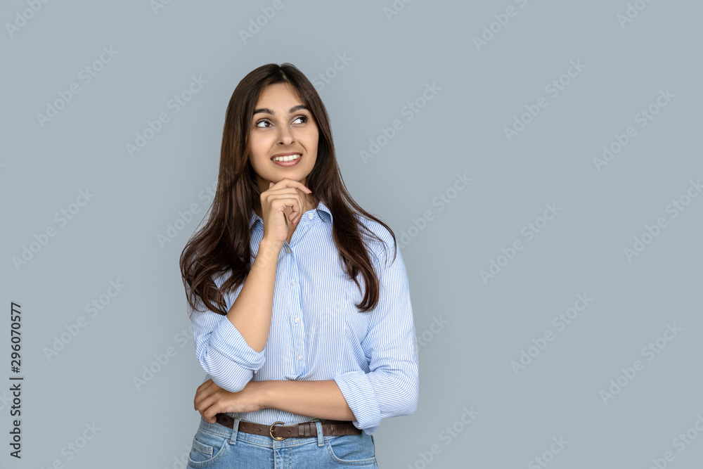 Dreamy thoughtful indian business woman student customer looking at copy space dreaming of success isolated on grey studio background thinking of career job education shopping sale offer Dreamy thoughtful indian business woman student customer looking at copy space dreaming of success isolated on grey studio background thinking of career job education shopping sale offer