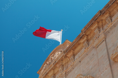 Bild auf Leinwand Maltese flag mounted on an old stone building