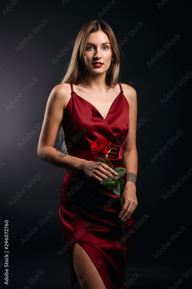 portrait of attractive awesome fair-haired woman in red dress holding a rose isolated on black studio. close up portrait, tenderness, love, romance, beauty , people portrait of attractive awesome fair-haired woman in red dress holding a rose isolated on black studio. close up portrait, tenderness, love, romance, beauty , people