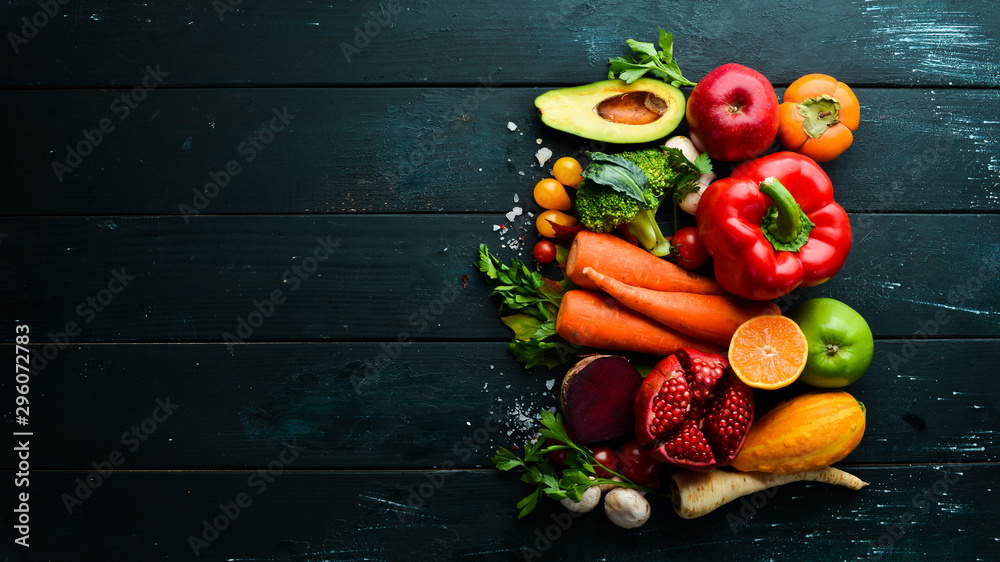 Fresh vegetables and fruits on black stone background. Healthy food. Top view. Free copy space.