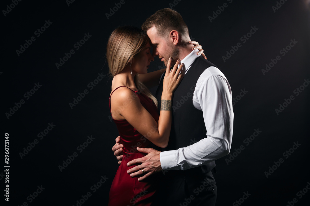 passionate man and woman hugging , kissing during the party. close up side view photo, isolated balck background, studio shot passionate man and woman hugging , kissing during the party. close up side view photo, isolated balck background, studio shot