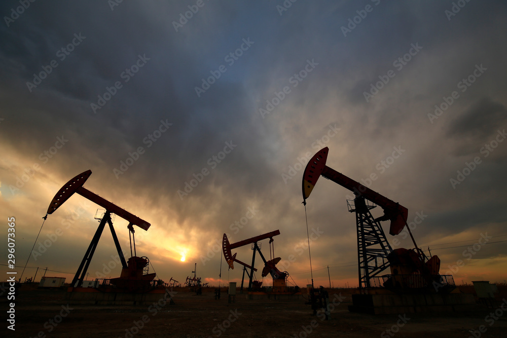 Is operation of pumping unit, sunset in oil field