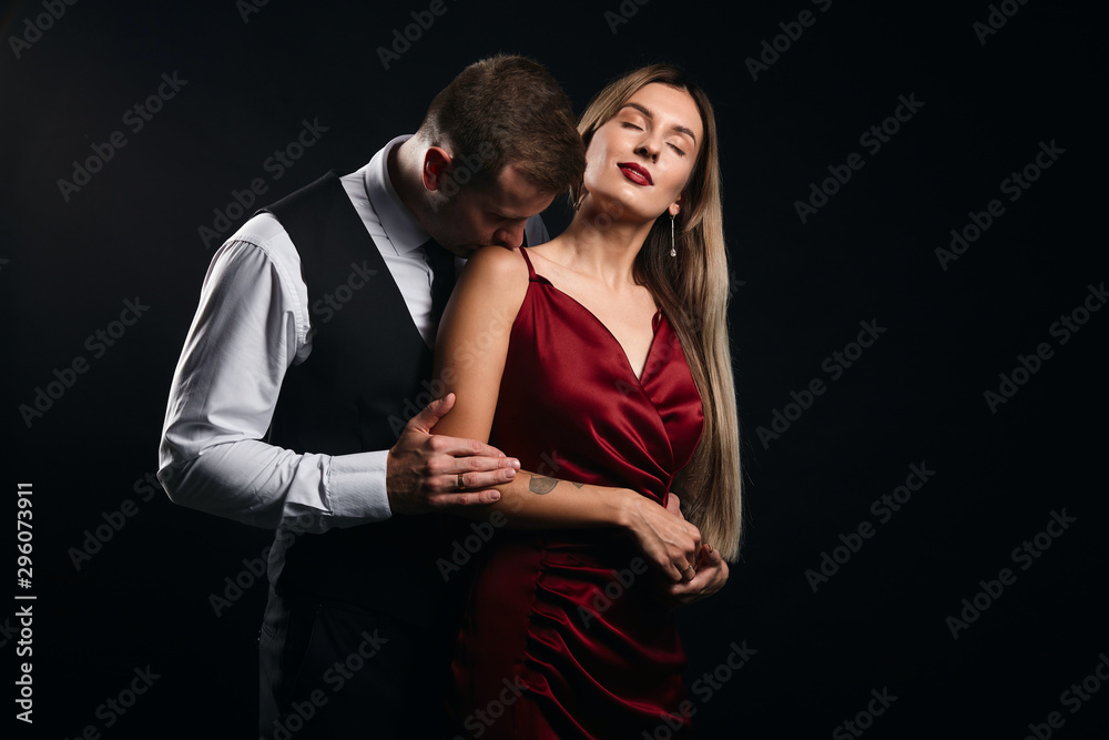 young pleasant man in shirt taking off his woman's dress, close up portrait, isolated black background, studio shot , copy space young pleasant man in shirt taking off his woman's dress, close up portrait, isolated black background, studio shot , copy space