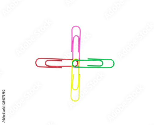 Four colorful paper clips in plus sign. Decorative paper clips in pink, yellow, green, and red colors