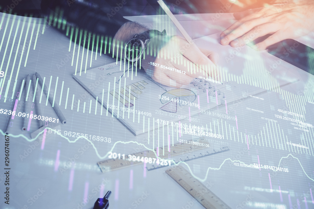 Double exposure of man's hands writing notes of stock market with forex chart. Double exposure of man's hands writing notes of stock market with forex chart.