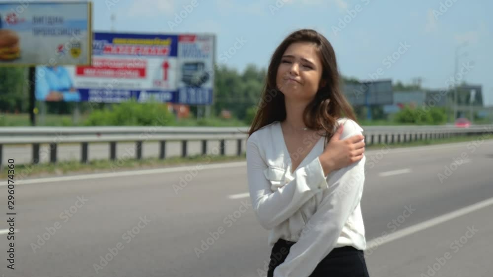 beautiful young brunette woman trying to stop passing by cars on the road looks upset beautiful young brunette woman trying to stop passing by cars on the road looks upset