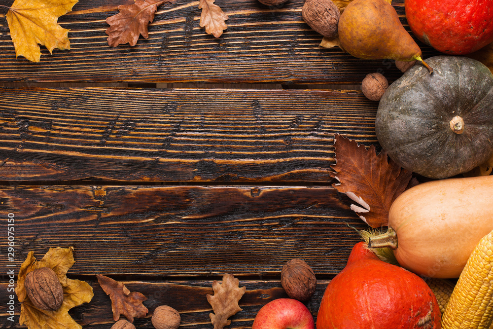 Different vegetables, pumpkins, apples, pears, nuts, tomatoes, corn, dry yellow leaves on wooden background. Autumn mood, copy space. Harvest concept. Different vegetables, pumpkins, apples, pears, nuts, tomatoes, corn, dry yellow leaves on wooden background. Autumn mood, copy space. Harvest concept.
