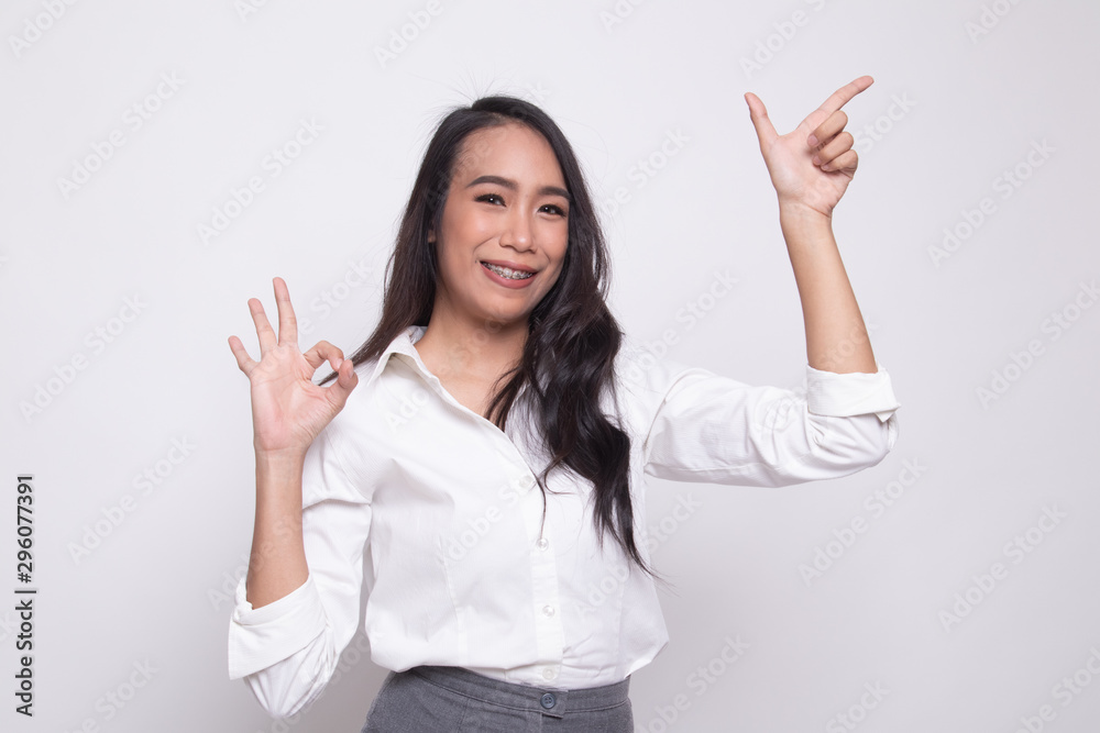 Young Asian woman point and show OK.