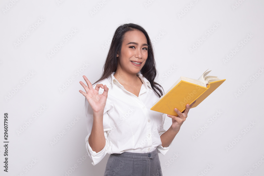 Young Asian woman show OK with a book. Young Asian woman show OK with a book.