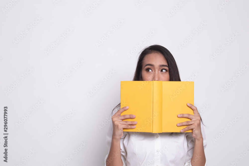 Young Asian woman with a book cover her face. Young Asian woman with a book cover her face.