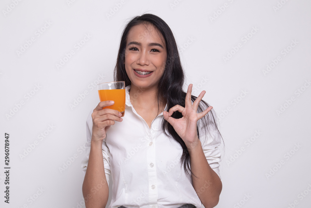 Young Asian woman drink orange juice show OK sign. Young Asian woman drink orange juice show OK sign.