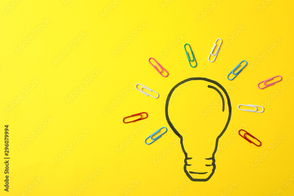 Drawn light bulb and clips on yellow background. Good idea concept