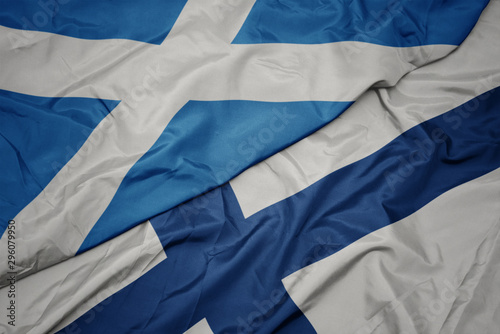waving colorful flag of finland and national flag of scotland.