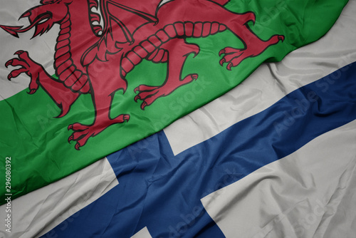 waving colorful flag of finland and national flag of wales.