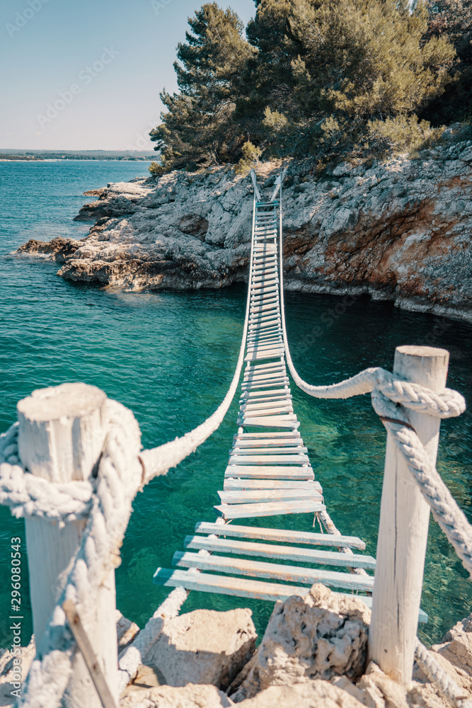 Fototapeta premium Most linowy nad klifem w Punta Christo, Pula, Chorwacja - Europa. Fotografia podróżnicza, idealna do magazynów i artykułów turystycznych.
